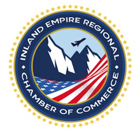 Logo of the Inland Empire Regional Chamber of Commerce with mountains, a plane, and the American flag in a circular design with stars.