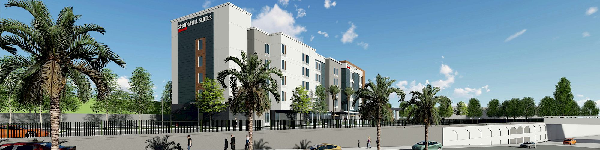 A modern hotel building is seen from across the street, surrounded by palm trees and parked cars, with people walking along the sidewalk.