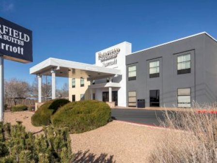 The image shows the exterior of a Fairfield Inn & Suites by Marriott with a clear blue sky in the background.