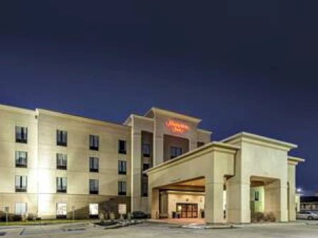 A multi-story hotel building illuminated at night with a prominent entrance canopy and several windows.