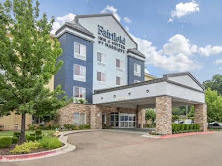 This image shows the exterior facade and entrance of a Fairfield Inn & Suites by Marriott hotel on a clear day.