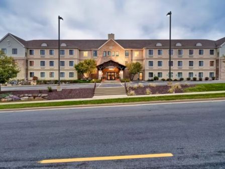 The image shows a large, multi-story building that appears to be a hotel or similar establishment, with a well-maintained exterior.
